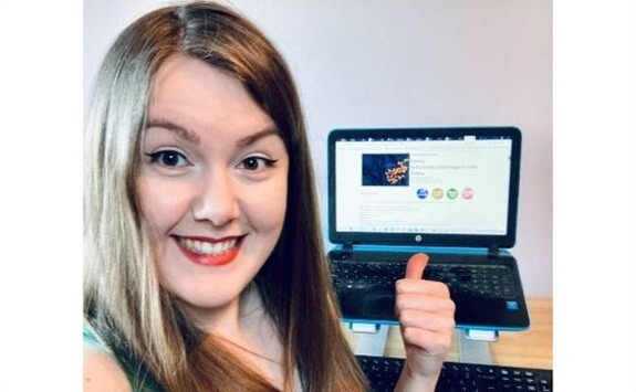 Esther Fearn with thumbs up in front of her laptop